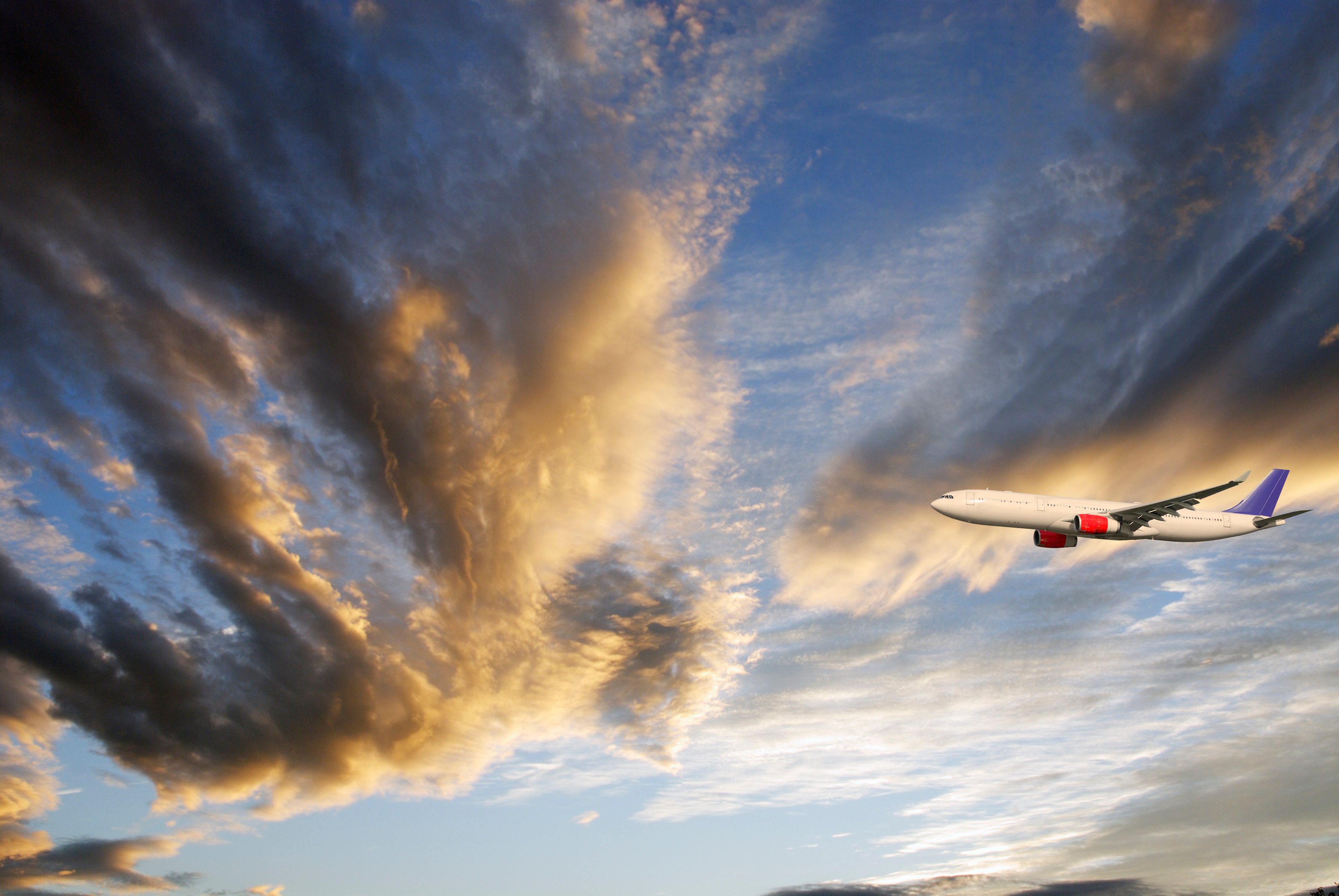 airliner-flying-through-cloud-scapes-blue-sky-SBI-300981561