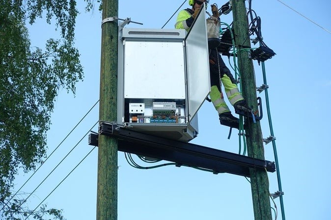 A person climbing a power pole

Description automatically generated